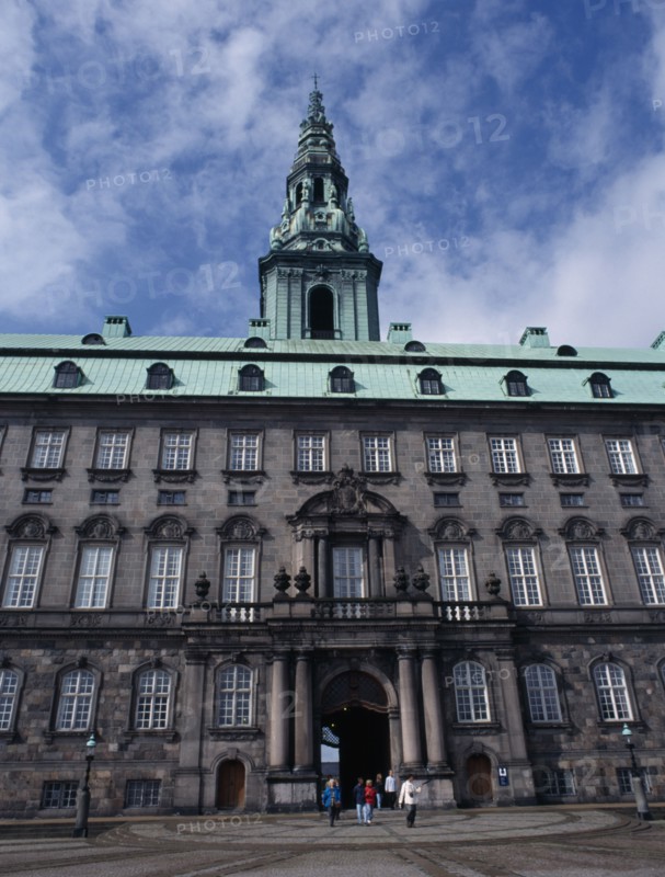 DENMARK, Copenhagen, Christiansborg Palace. Home of the Danish Parliament. Exterior view with green copper roof and visitors walking through.