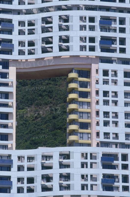 HONG KONG, Discovery Bay, Blue apartment building designed with a hole in it showing the green hills behind