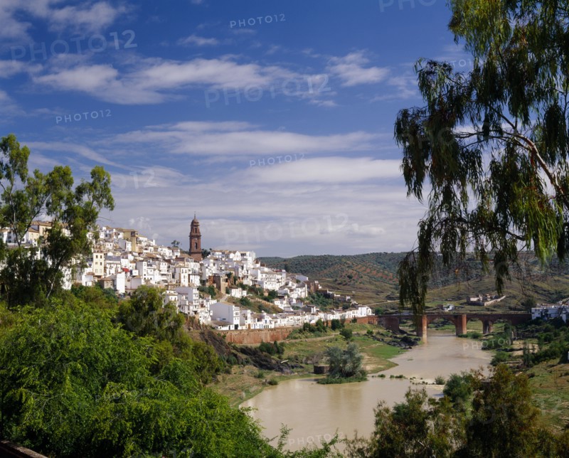 SPAIN, Andalucia, Cordoba Province, "Montoro, view over white painted hillside village with river and bridge in front "