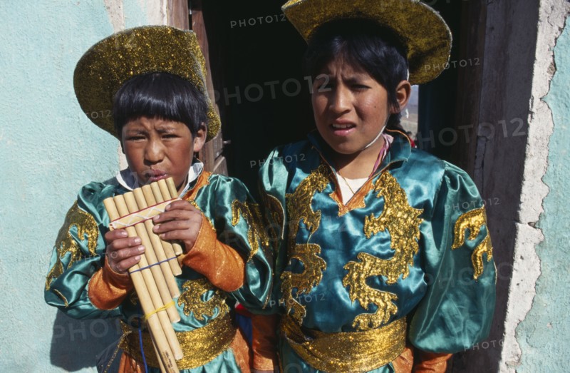 BOLIVIA, Potosi, Two boys in costume blowing pipe