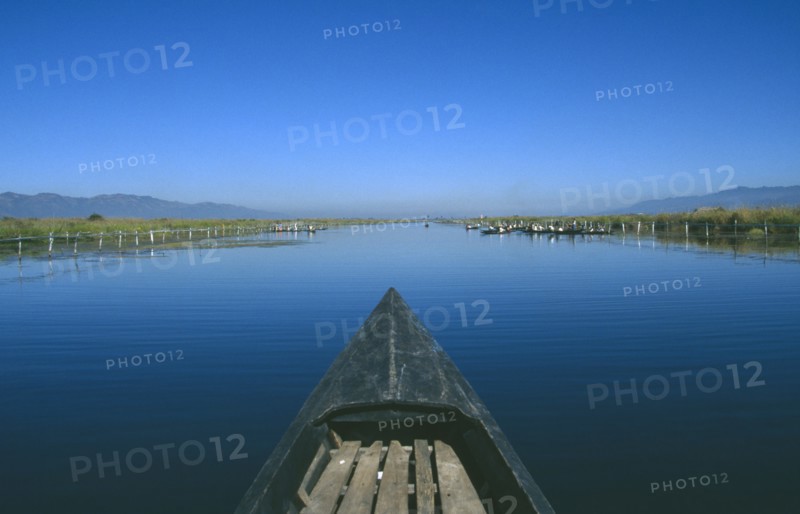 MYANMAR, Inle Lake, View along canal over the prow of a wooden boat