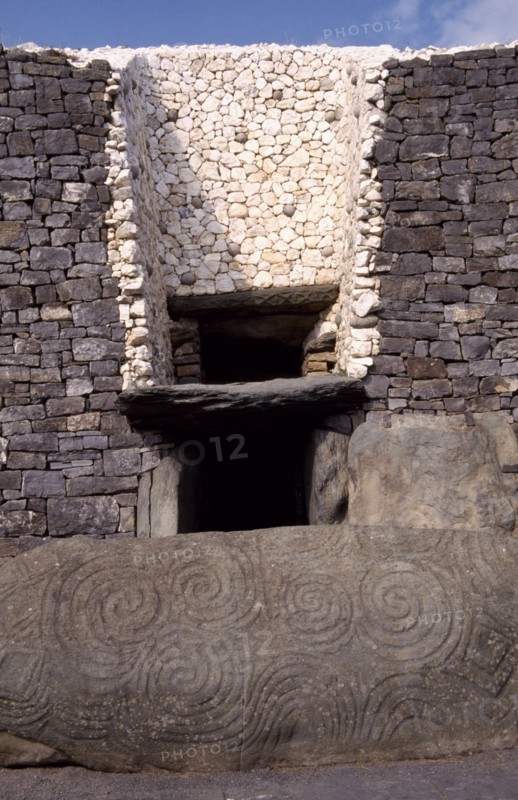 IRELAND, County Meath, Newgrange, Entrance to Prehistoric Burial Site in the Boyne Valley with carved stone in the foreground