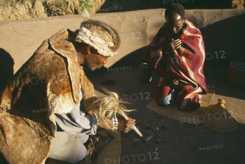 SOUTH AFRICA, Qwa-Qwa, Basotho Village, Basotho Cultural Village.  Local man consulting a Diviner using stones.
