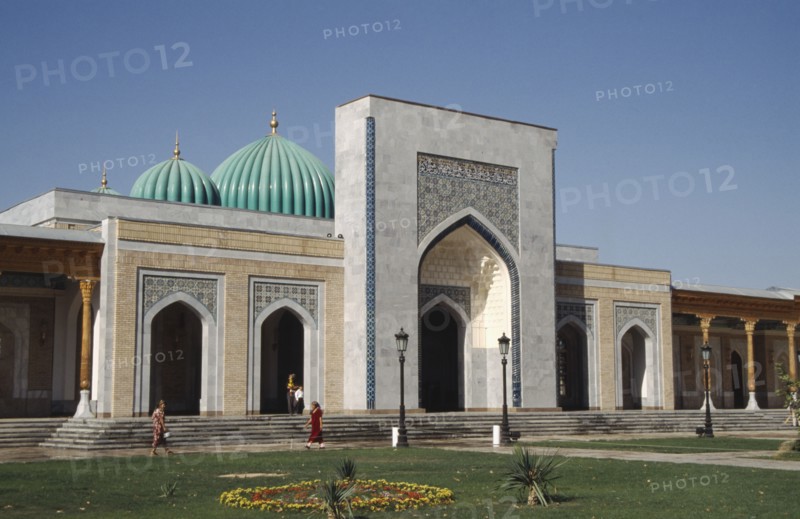 UZBEKISTAN , Near Samarkand, Al Bukhari Mausoleum facade and lawns with passing people