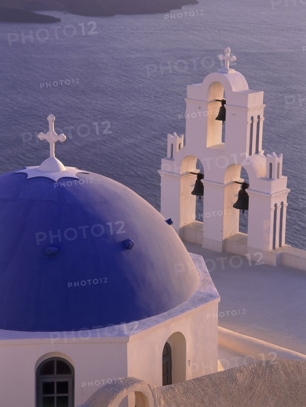 GREECE, Cyclades Islands, Santorini, Thira detail of blue and white church dome and bell tower at dusk with the sea below