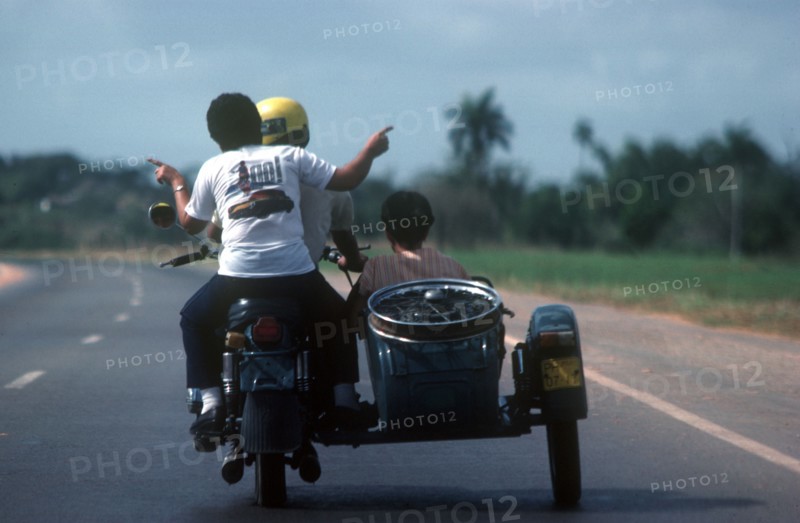 CUBA, Havana, View from behind a motorcycle and sidecar with passengers