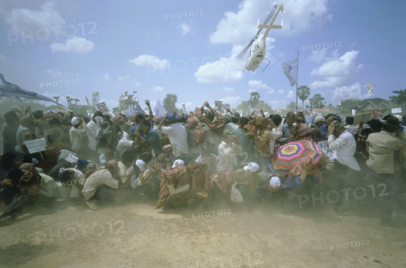 CAMBODIA, General, UN helicopter carrying Prince Ranaridth Sihanouk during the 1993 elections takes off above a crowd of his supporters leaving them in a dust storm