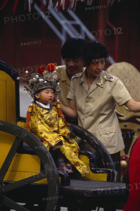 CHINA, Beijing, One child family.  Little boy dressed as emperor posing for photograph