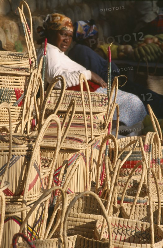 SOUTH AFRICA, KwaZulu-Natal, St.Lucia Village, Zulu woman selling hand woven baskets made from Lala Palm  (Hyphaene Coriacea).