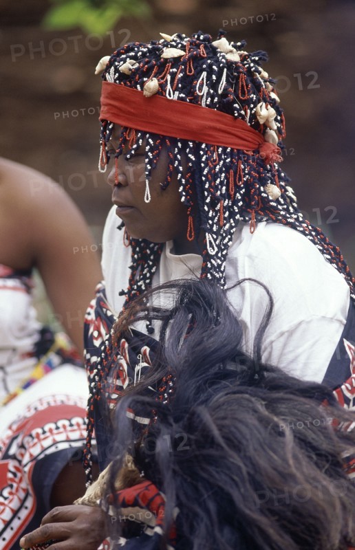 SOUTH AFRICA, KwaZulu Natal, Local woman in traditional headress holding fly whisk made from wildebeast tail