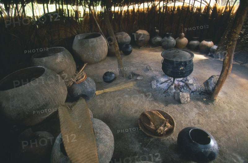SOUTH AFRICA, KwaZulu-Natal , Melmoth, Simunye Lodge.  Interior of beer making hut with large vessels and pot on an open fire.