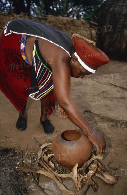 SOUTH AFRICA, Kwa Zulu Natal , Eshowe, Zulu woman preparing fire for firing pot.
