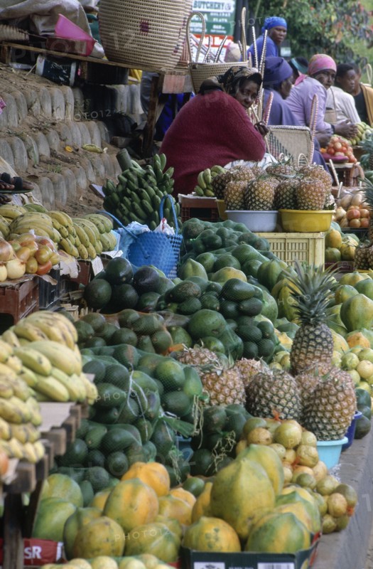 SOUTH AFRICA , KwaZulu Natal, St Lucia, Zulu women at street stall selling fruit and hand woven baskets made from fronds of Lala palm (Hyphaene Coriacea)