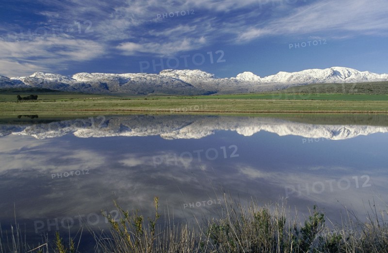 SOUTH AFRICA, Western Cape, Ceres, Landscape with snow covered mountains reflected in dam in the foreground.
