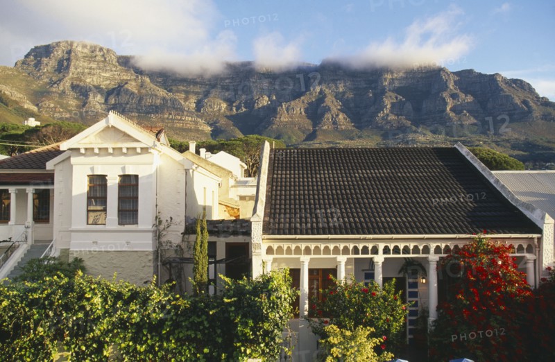 SOUTH AFRICA, Cape Province, Cape Town, Houses and gardens in the foreground and Table Mountain and 'Table Cloth' mist in background.