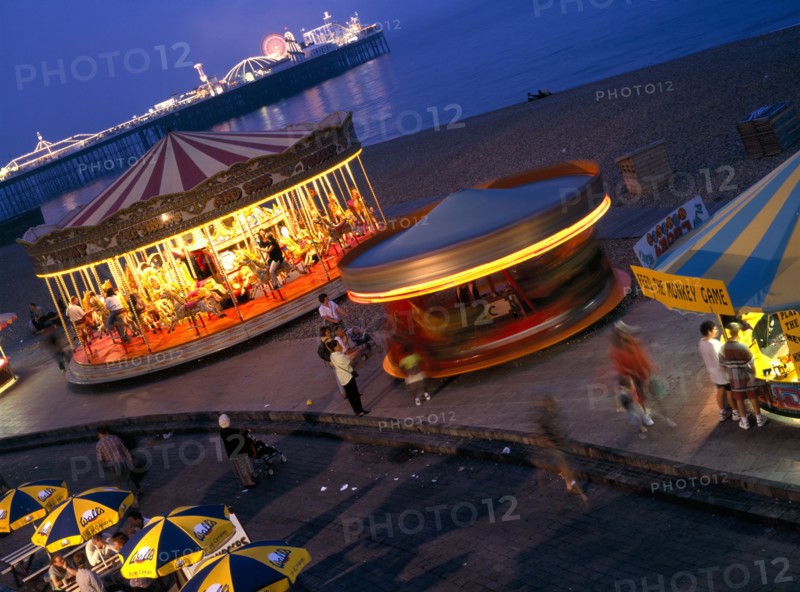 ENGLAND, East Sussex, Brighton, Seafront amusements and Brighton Pier illuminated at night