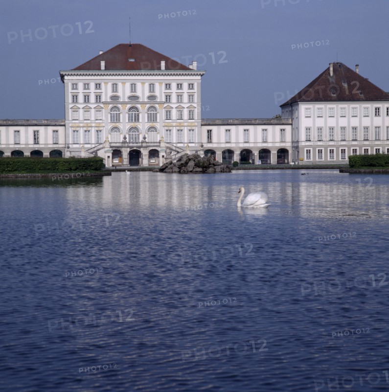 GERMANY, Bavaria,  Munich, Schloss Nymphenburg. Viewed across canal with reflection and swan on water