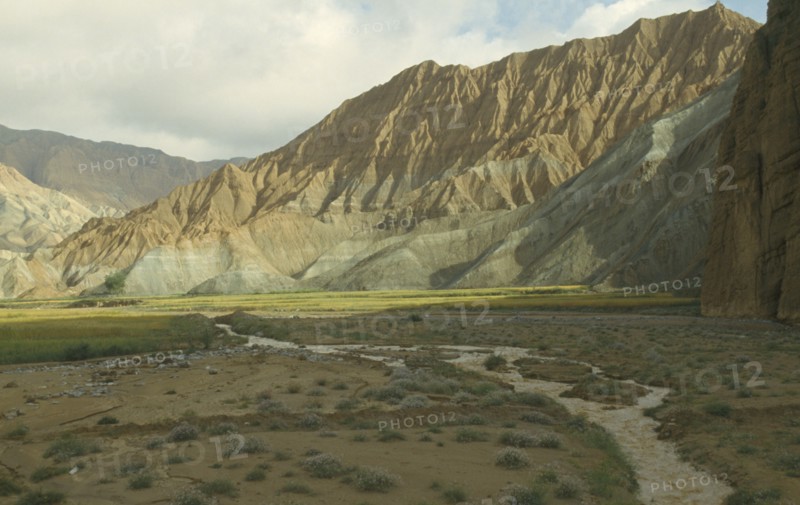 CHINA, Qinghai  , Yellow River , Eroded rocks above wheat fieldin  high altitude remote valley