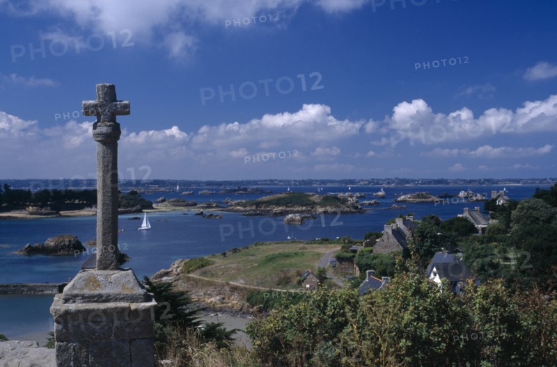 FRANCE, Brittany, Ile De Brehat, Coastal view from the Churchyard with stone cross in the foreground