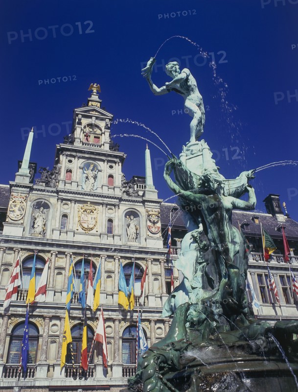 BELGIUM, Antwerp, Town Hall facade decorated with flags and the Brabo Fountain in the foreground