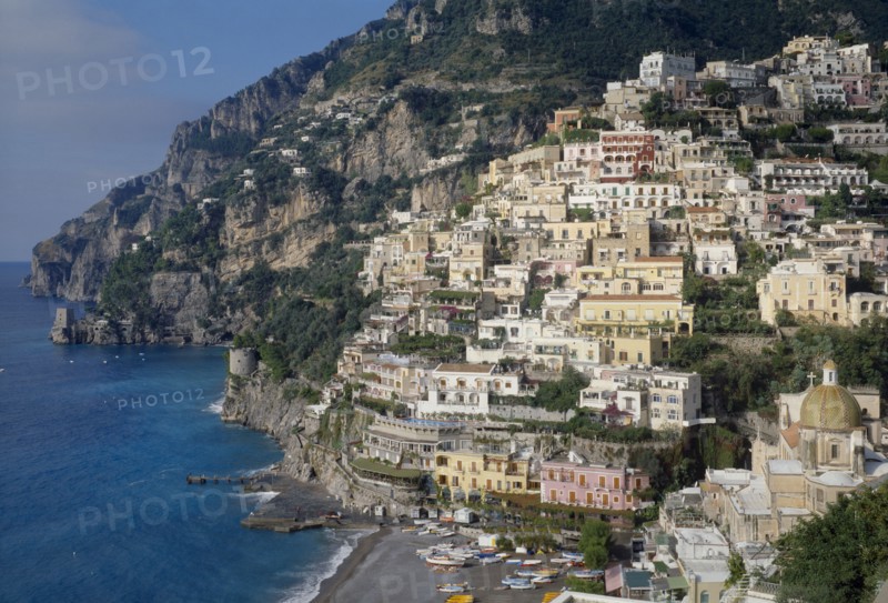 ITALY, Campania, Amalfi Coast, Near Positano. Elevated view towards hillside town buildings overlooking the beach and sea
