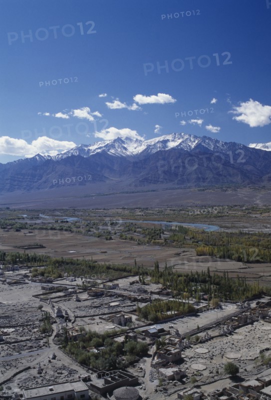 INDIA, Ladakh, Leh Valley , General view over the valley and River Indus with scattered buildings in the foreground and snow capped mountains on the horizon