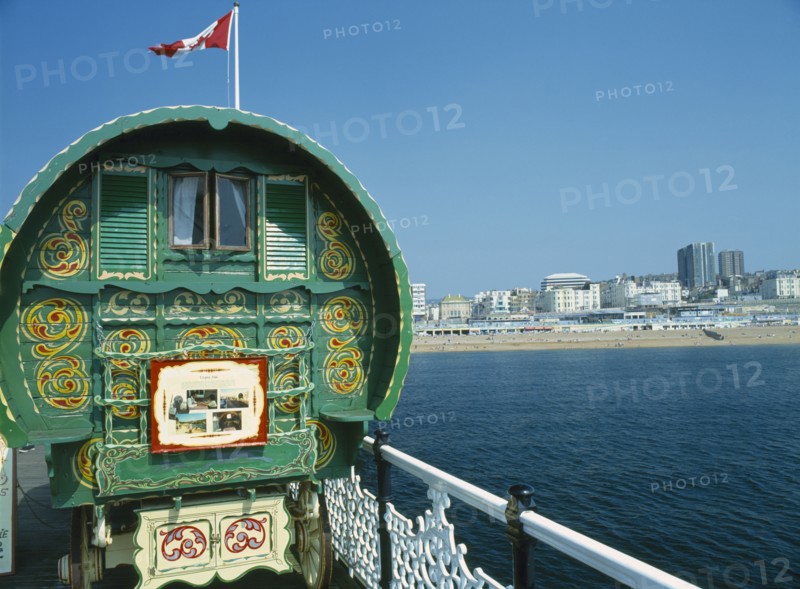 ENGLAND, East Sussex , Brighton, Brighton Pier Gypsy Caravan with Kemptown skyline behind .