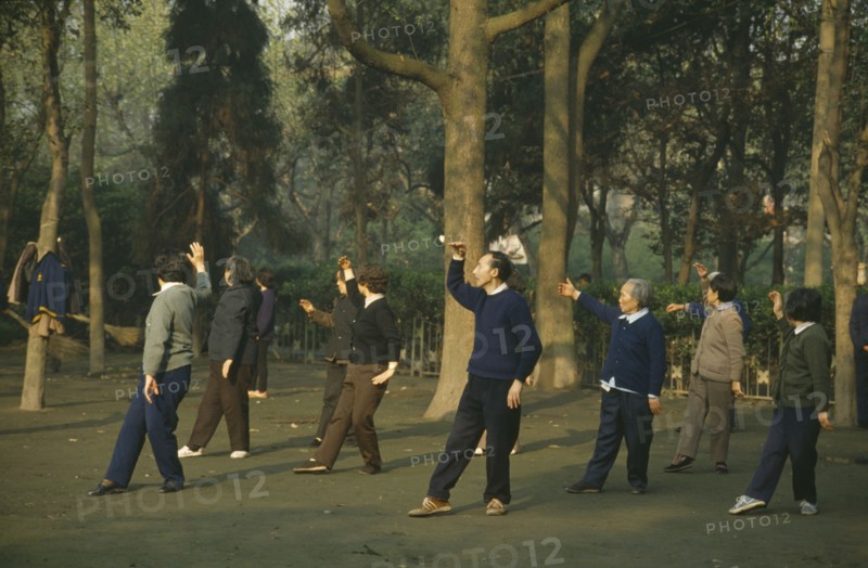 CHINA, Sichuan Province, Chengdu, Group exercise in park at dawn.