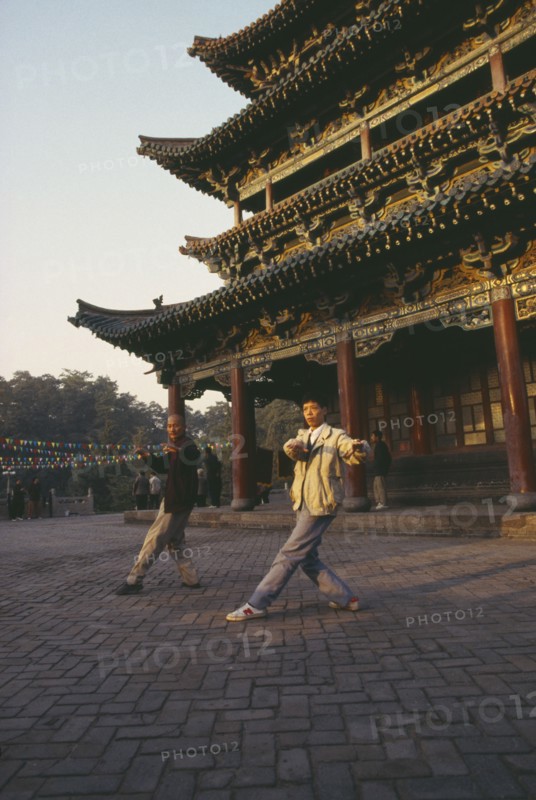 CHINA, General, Tai Chi, Two men doing morning exercises outside Buddhist temple