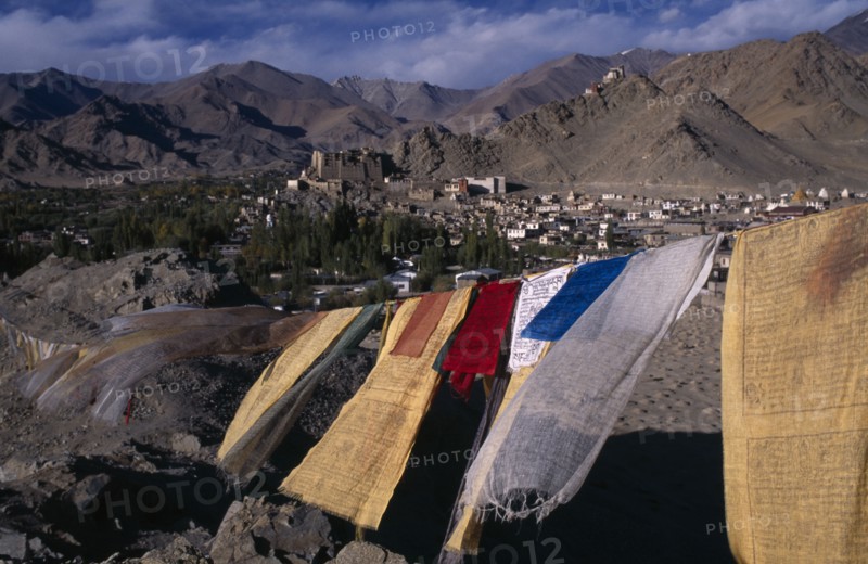 INDIA, Ladakh , Leh , View over Leh Valley and town from hill-top with line of prayer flags flying in wind in foreground.