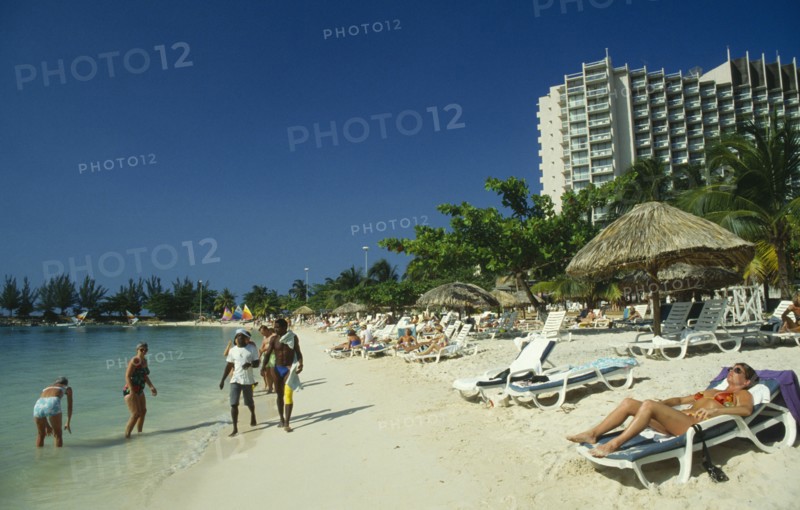 WEST INDIES, Jamaica , Ocho Rios , Sunbathers on the beach with hotel behind