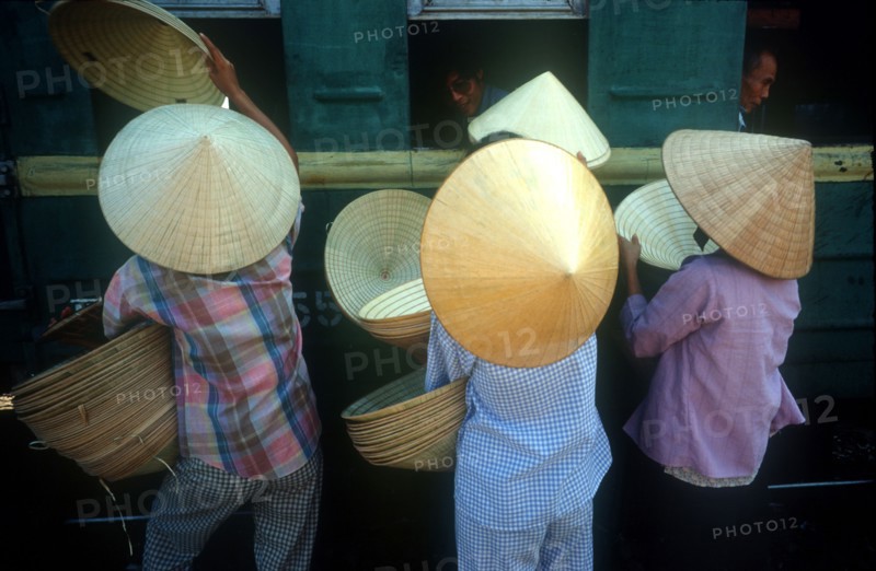 VIETNAM, Hue, Women selling hats to train passengers from platform