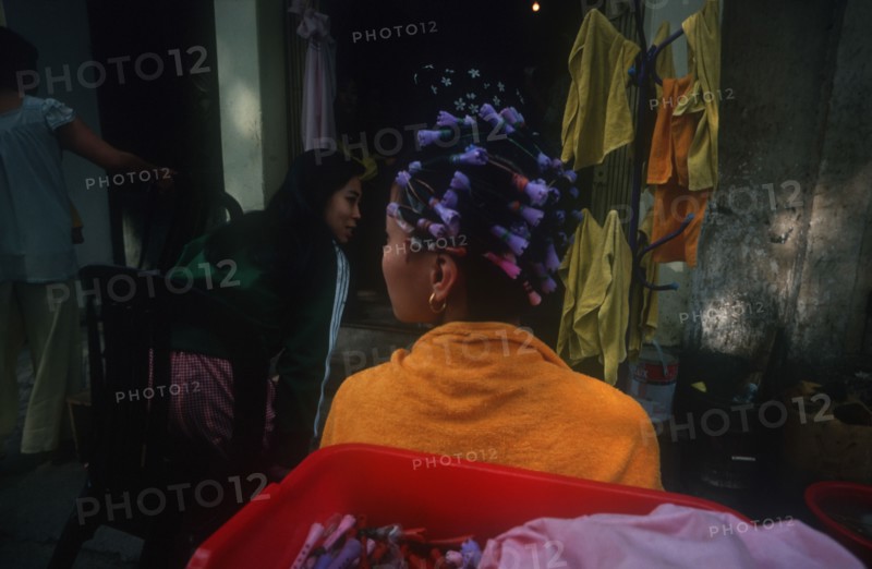 VIETNAM, Hanoi , Woman standing facing the other way with curlers in her hair