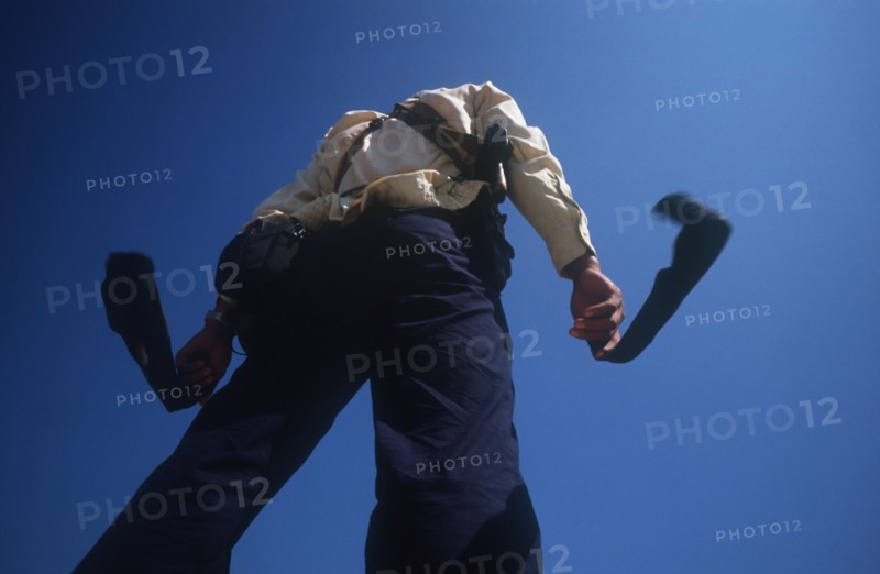 CAMBODIA, Military, Paratrooper drying his socks on the Mekong going towards Kroch Chmar.  Viewed from below against sky.