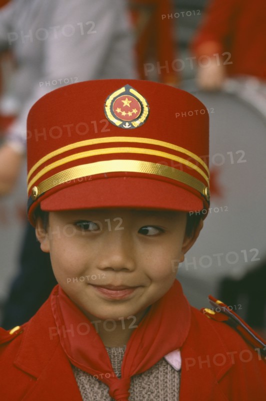 CHINA, Sichuan Province, Chengdu,  Portrait of young Boy in band wearing red and gold hat