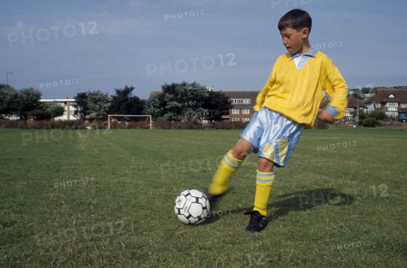 SPORT, Ball Games, Soccer, Young boy kicking football.