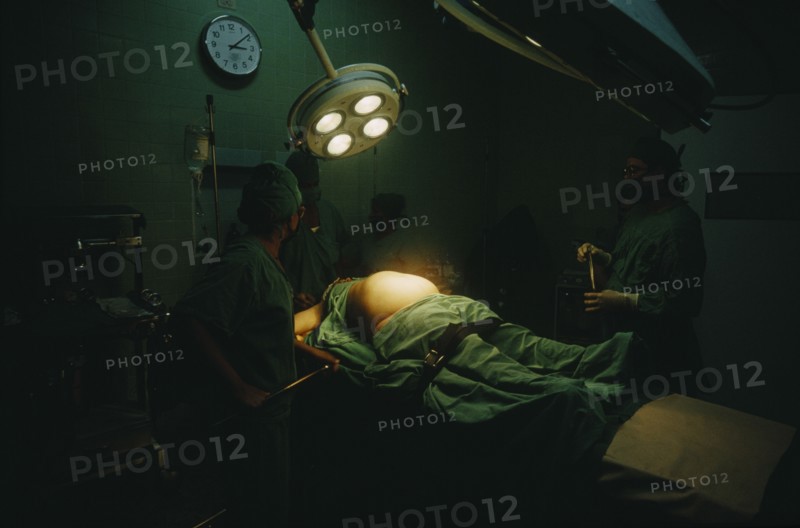 CUBA, Havana, Woman in labour lying on an operating table at the maternity hospital with lamps above her belly