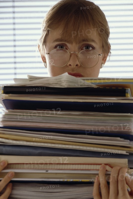 INDUSTRY, Office, Paperwork, Female office worker holding a large bundle of paperwork in her arms