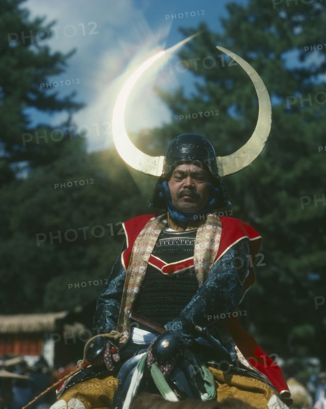 JAPAN, Honshu, Kyoto, Man on horseback in a Samuri Costume with the sun reflecting off his horned helmet