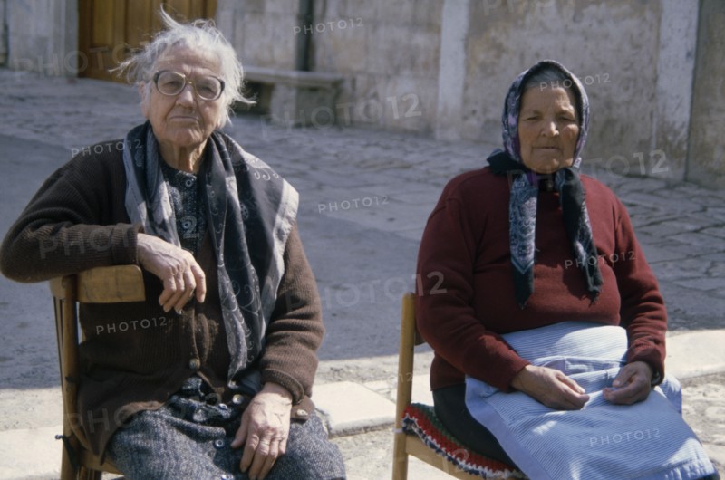 ITALY, Apulia , Two elderly women sitting on chairs in street