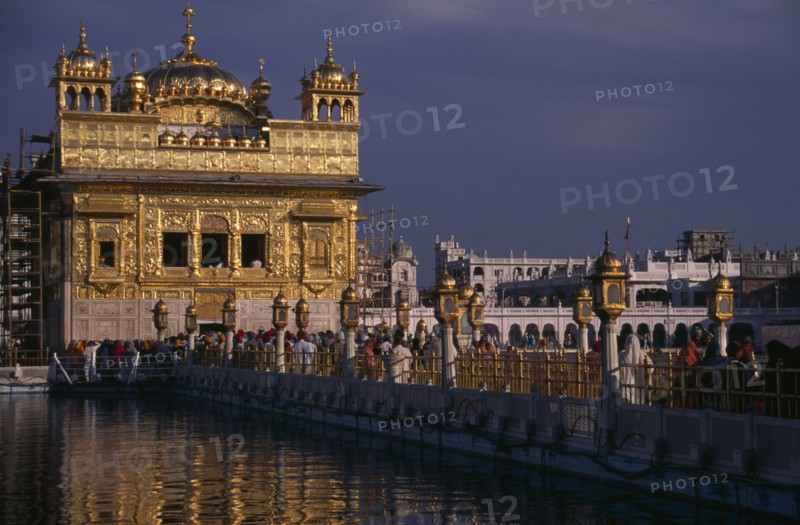 INDIA, Punjab, Amritsar, The Sikh Golden Temple with people on the walkway across the water