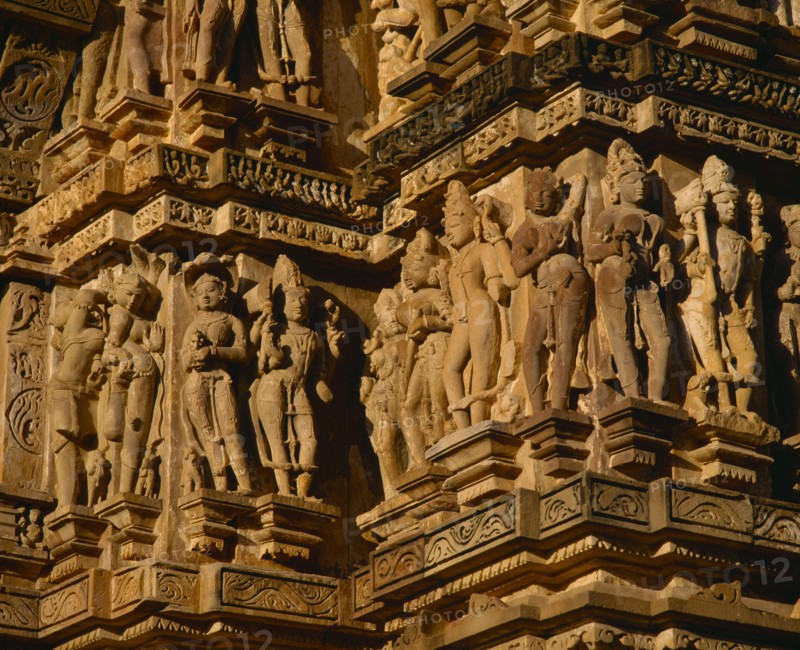 INDIA, Madhya Pradesh, Khajuraho, Vishvanath Temple.  Detail of ornate carved figures around side.