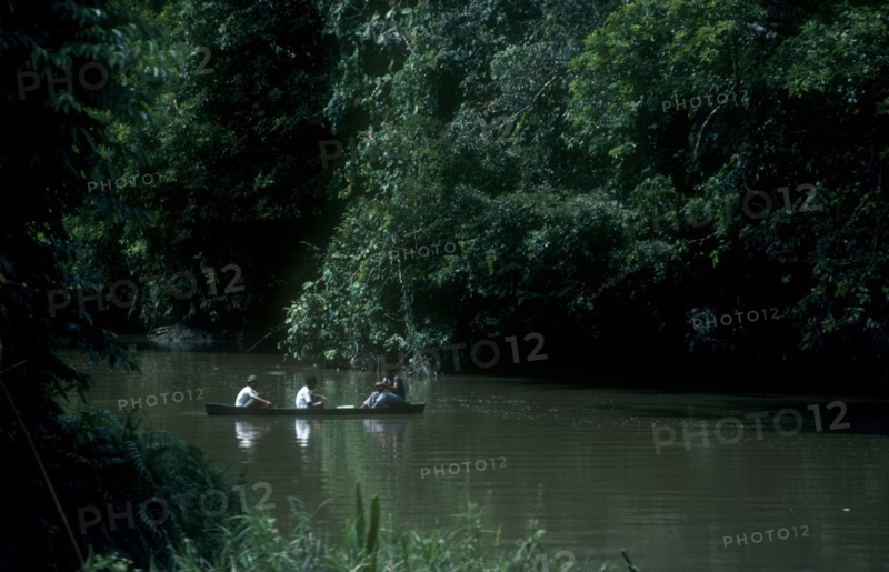 BRUNEI, Industry, Three men in a canoe fishing on a river in the jungle interior