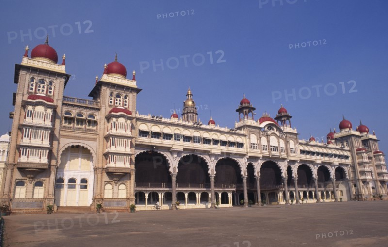 INDIA, Karnataka , Mysore , Angled view of exterior of Mysore Palace also known as Amba Vilas Palace with passing cyclist.