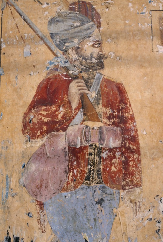 INDIA, Rajasthan , Shekhawati Region, Lachhmangarh. Old mural of a man holding a rifle