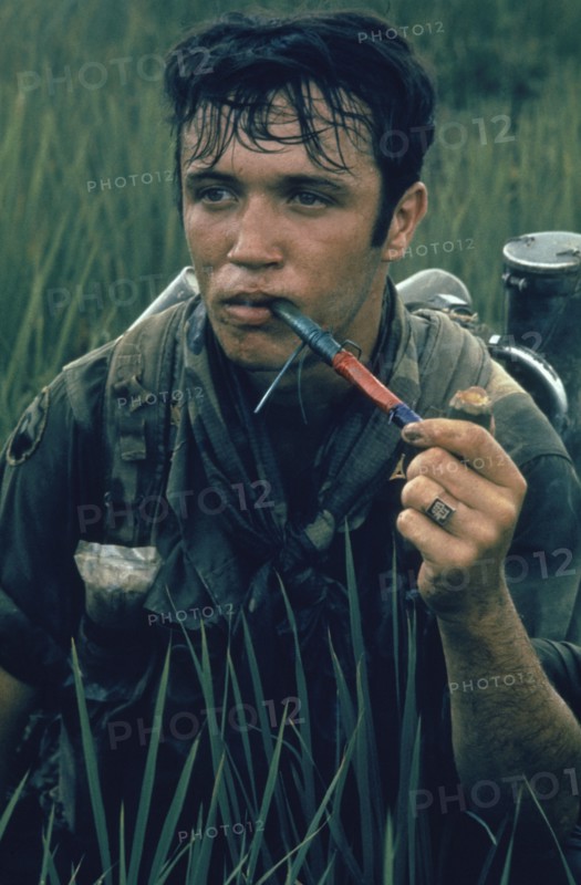 VIETNAM, War, 1968, 9th Division soldier near Tan An sitting in a rice paddy smoking Cambodian Red in a pipe