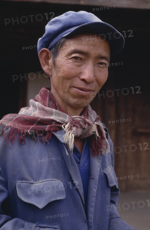 CHINA, Yunnan, Baisha, Portrait of a Naxi man wearing a cap and scarf