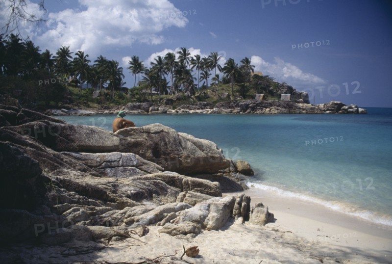 THAILAND, Koh Pha-Ngan Island, Coral Bay, View from beach over rocks toward bay surrounded by rocks and palms