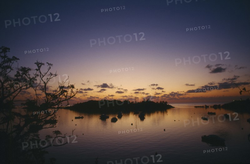BERMUDA, Elys Harbour, Sunset over small island and moored boats