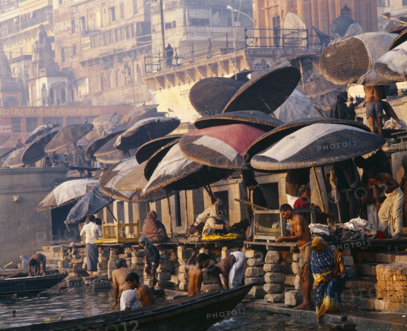 INDIA, Uttar Pradesh, Varanasi, Umbrellas over the ghats along the River Ganges.